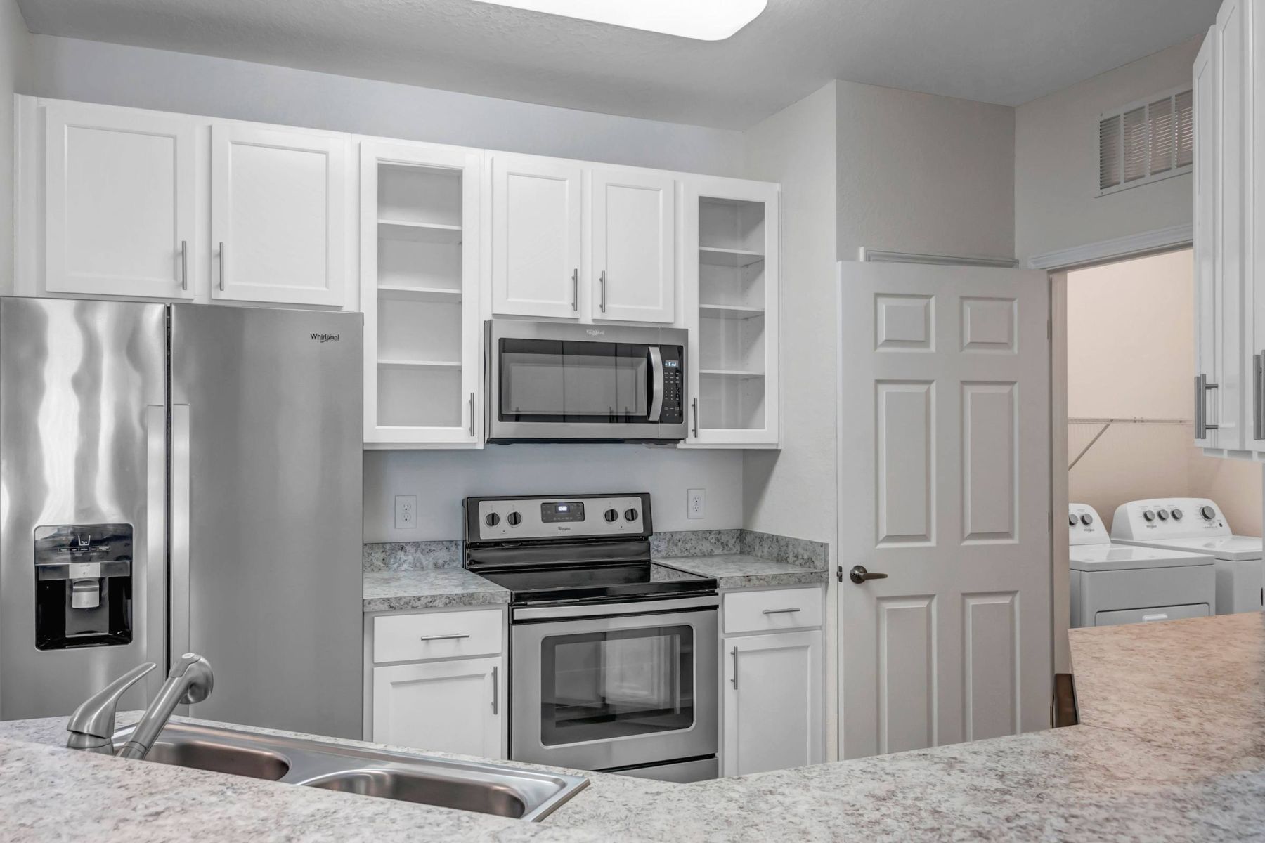 Luxury apartment kitchen with stainless steel appliances, granite countertops, and lots of storage space